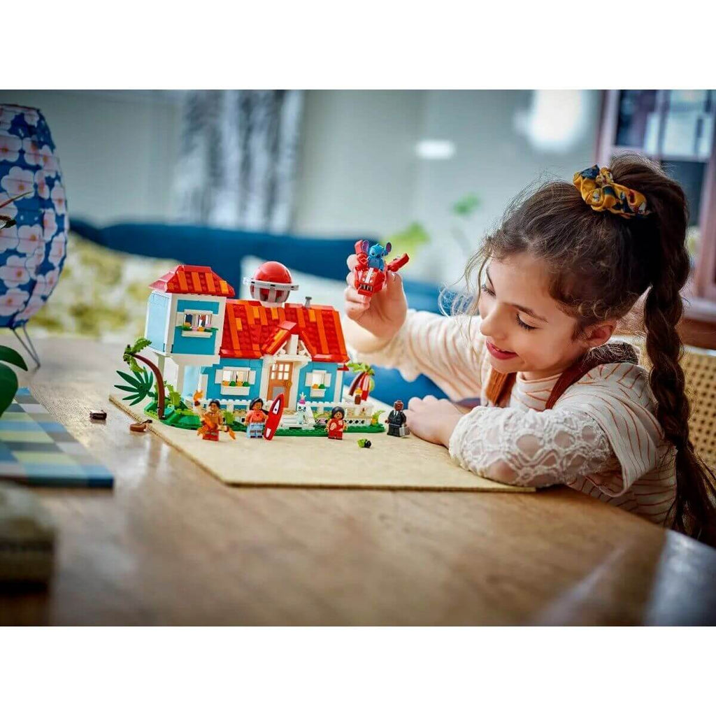 Child playing with Construction set Lego Disney Lilo & Stitch 43268 834 Pieces, colorful building set on table.