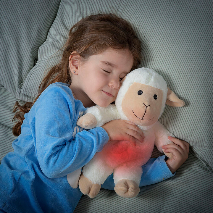 Sheep Soft Toy with Warming and Cooling Effect Wooly InnovaGoods being cuddled by a child in bed.