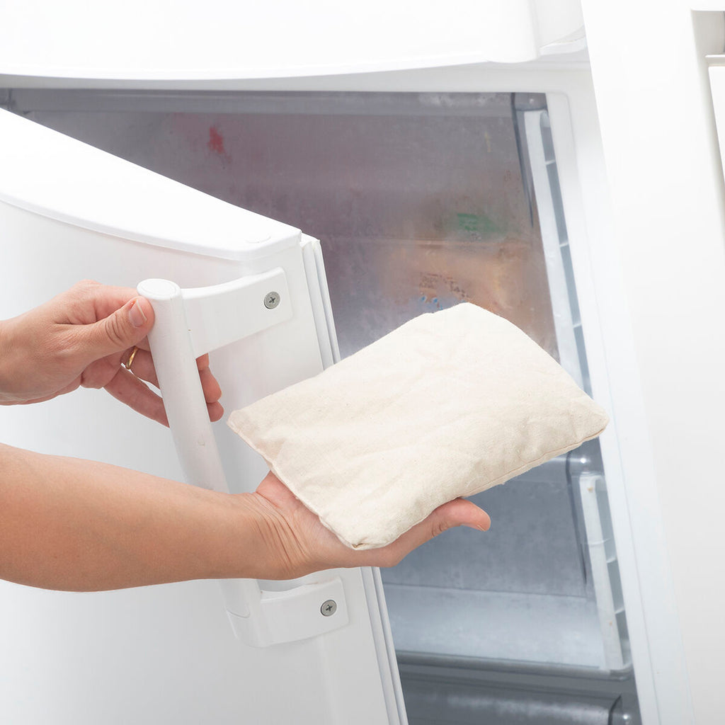 Person holding the Sheep Soft Toy with Warming and Cooling Effect Wooly InnovaGoods near an open refrigerator.
