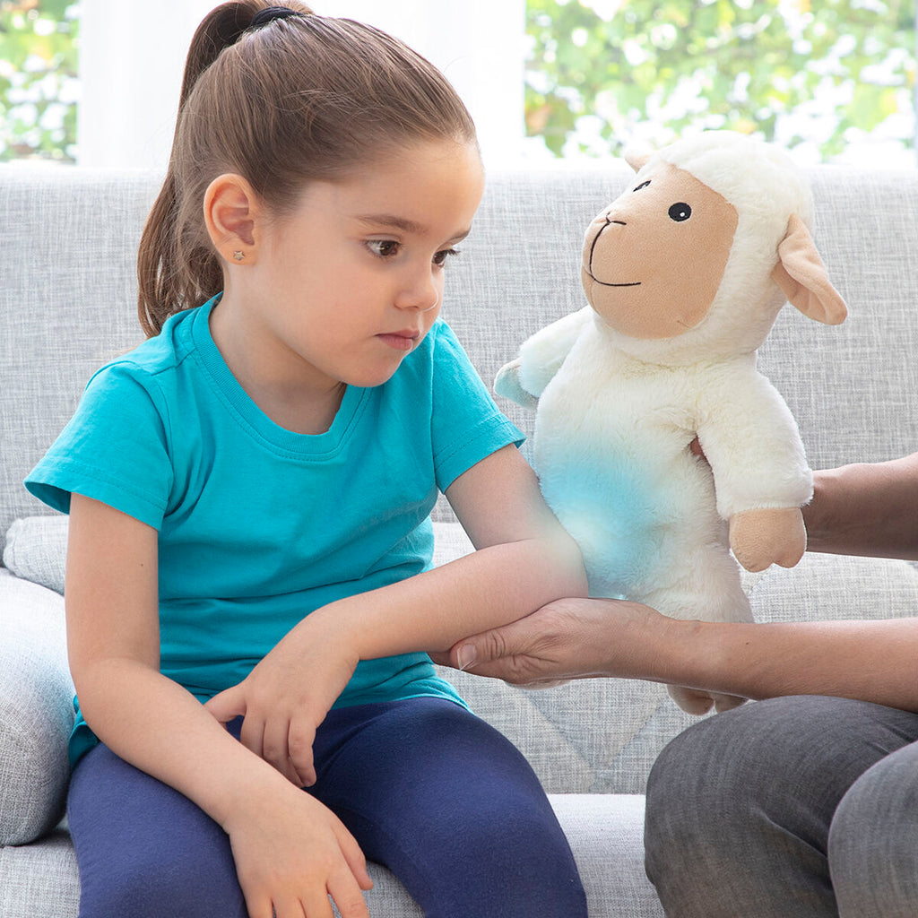 Child holding Sheep Soft Toy with Warming and Cooling Effect Wooly InnovaGoods, enjoying comfort and fun.