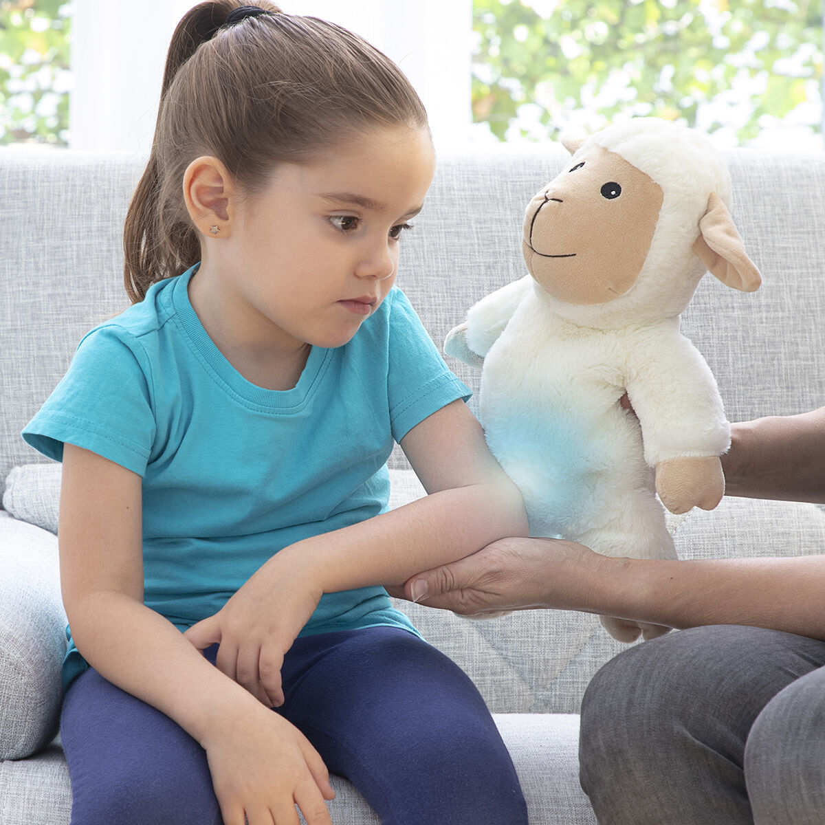 Child holding Sheep Soft Toy with Warming and Cooling Effect Wooly InnovaGoods, enjoying comfort and fun.