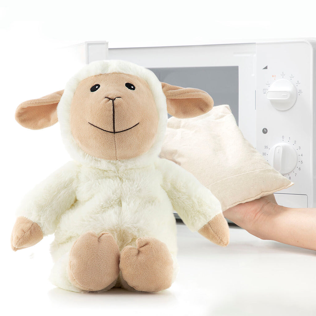 Sheep Soft Toy with Warming and Cooling Effect Wooly InnovaGoods next to a microwave and warming pouch.